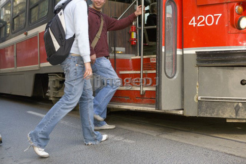 Passengers getting on electric Streetcar, Toronto Transit System, no carbon emissions; Canada, Ontario, Toronto