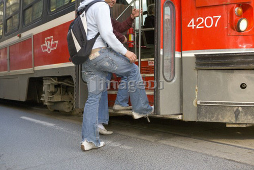 Passengers getting on electric Streetcar, Toronto Transit System, no carbon emissions; Canada, Ontario, Toronto