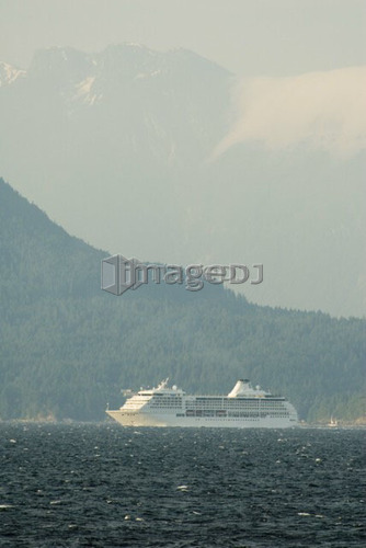 A Cruise ship passing below a large mountain; Canada, British Columbia, Nanaimo