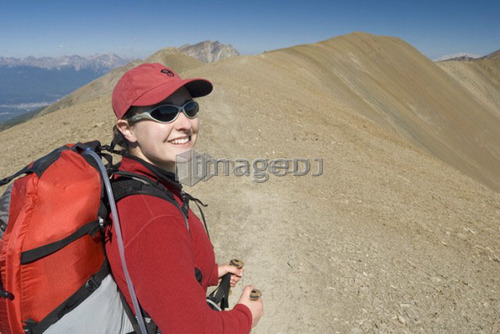 A woman (20-25) smiles while hiking in the alpine; Canada, Alberta, Jasper National Park, Skyline Trail
