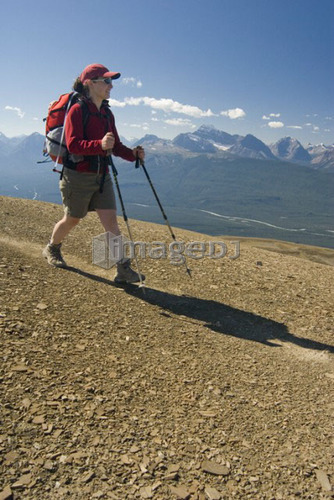 A woman (20-25) smiles while hiking in the alpine; Canada, Alberta, Jasper National Park, Skyline Trail