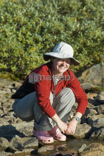 Woman (20-25) by an alpine creek; Canada, Alberta, Jasper National Park, Skyline Trail