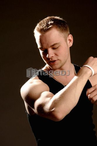 Portrait of young man (21 years of age) showing his bicep; Canada, Saskatchewan, Regina