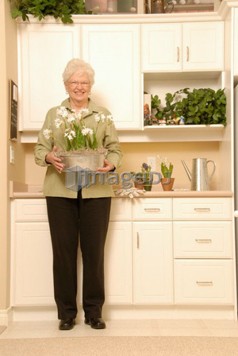 Senior Woman with plants; Canada, Saskatchewan, Regina
