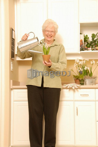 Senior Woman with plants; Canada, Saskatchewan, Regina