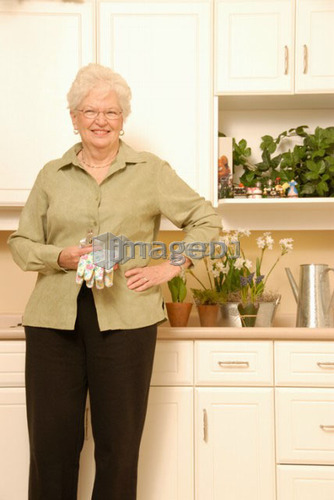 Senior Woman with plants; Canada, Saskatchewan, Regina