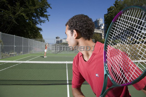 Couple playing tennis; Canada, British Columbia, Vancouver