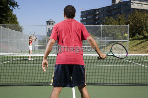 Couple playing tennis; Canada, British Columbia, Vancouver