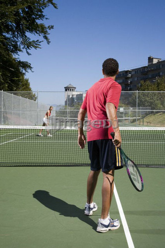 Couple playing tennis; Canada, British Columbia, Vancouver