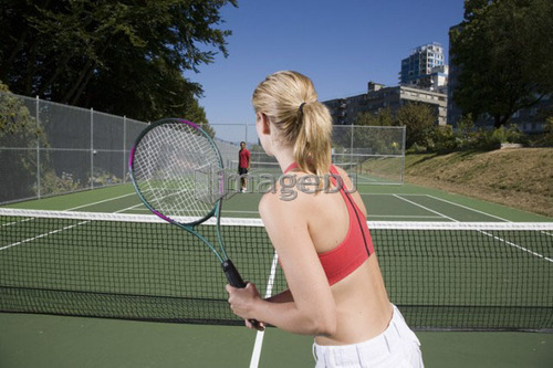 Couple playing tennis; Canada, British Columbia, Vancouver