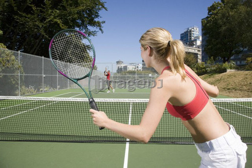 Couple playing tennis; Canada, British Columbia, Vancouver