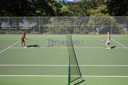 Couple playing tennis; Canada, British Columbia, Vancouver