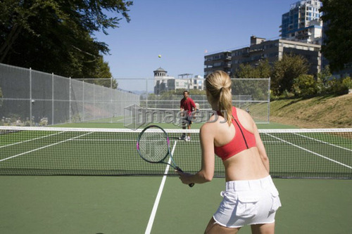 Couple playing tennis; Canada, British Columbia, Vancouver