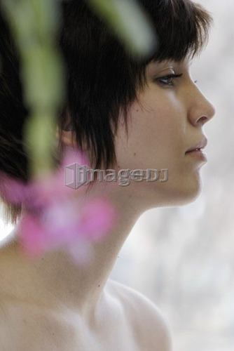 Cactus flower blurred in foreground of portrait of young woman, Canada, Manitoba, Brandon