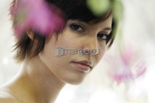 Cactus flower blurred in foreground of portrait of young woman, Canada, Manitoba, Brandon