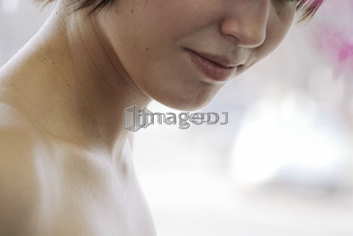 Cactus flower blurred in foreground of portrait of young woman, Canada, Manitoba, Brandon