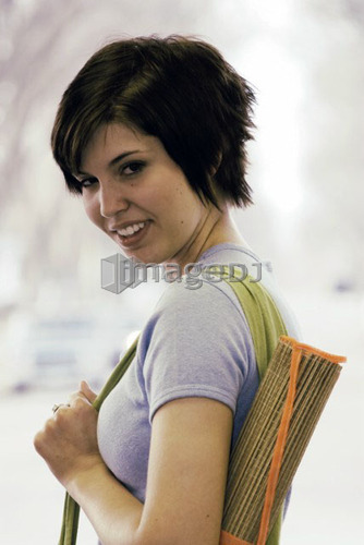 Young woman carrying bamboo mat and cloth shopping bag made with hemp fibres, Canada, Manitoba, Brandon