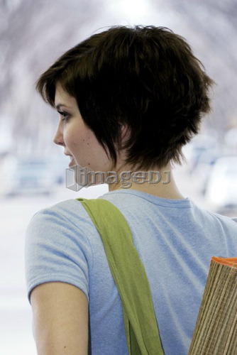 Young woman carrying bamboo mat and cloth shopping bag made with hemp fibres, Canada, Manitoba, Brandon