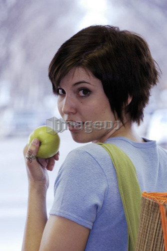 Young woman carrying bamboo mat and cloth shopping bag made with hemp fibres, Canada, Manitoba, Brandon