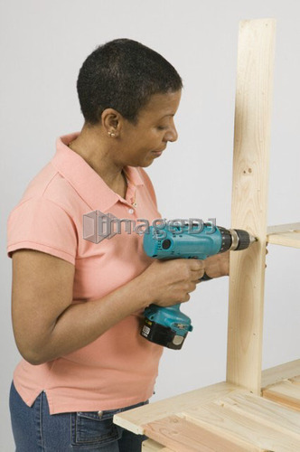 African American Woman Doing Home Improvement, Assembling a Shelving Unit, Canada, British Columbia