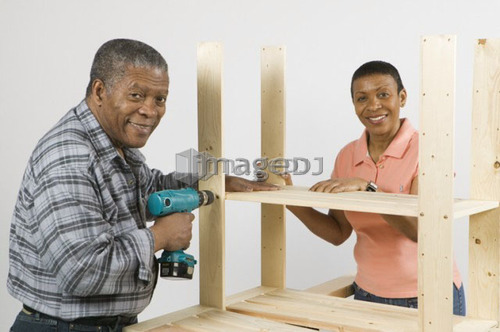 African American Couple Doing Home Improvement, Assembling a Shelving Unit, Canada, British Columbia