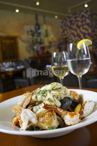 Seafood dish with white wine and glass of water in restaurant setting