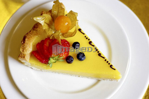 Piece of lemon fruit flan dessert on white plate