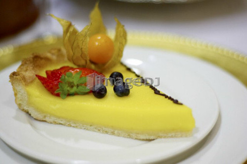 Piece of lemon fruit flan dessert on white plate