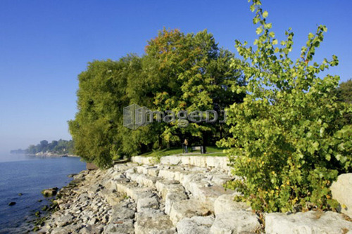 Person at edge of tiered rock embankment along Lake Ontario, Burlington