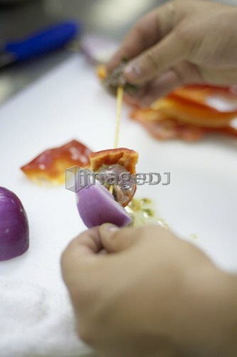 Detail of hands preparing shish kabobs