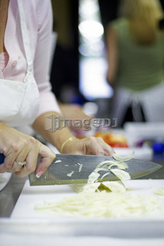 Chopping a celery stalk with large knife in the kitchen