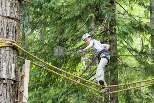 A woman works her way through a high ropes course at the Strathcona Park Lodge, BC