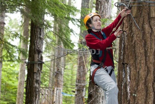 A woman works her way through a high ropes course at the Strathcona Park Lodge, BC