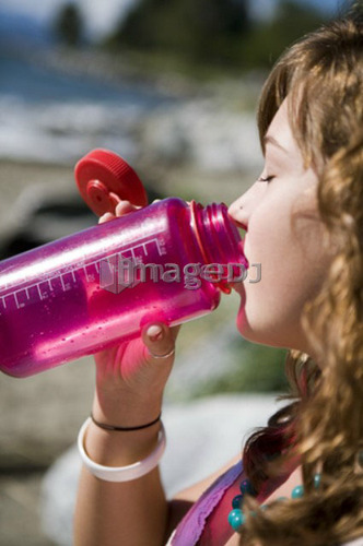 Female, 17, drinking from water bottle while at the beach, English Bay, Vancouver, BC