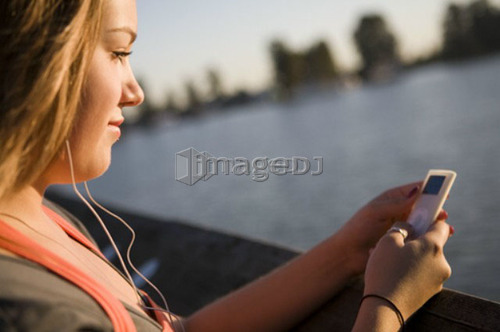 Female, 17, listening to ipod while on dock, Fraser River, Vancouver, BC