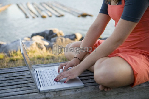 Crop image of female, 17, on laptop, outdoors, Fraser River, Vancouver, BC