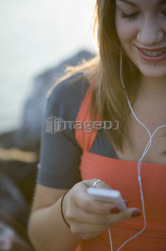 Female, 17, listening to ipod while outdoors, Fraser River, Vancouver, BC