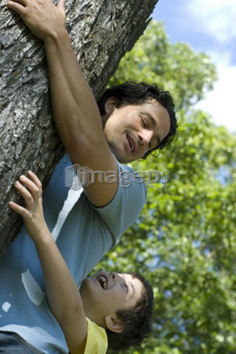 Six year old boy and father hugging tree, Assiniboine Park, Winnipeg, Canada
