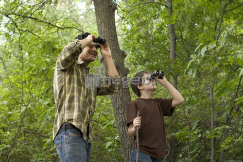 Young boy and father looking through binoculars, Assiniboine Park, Winnipeg, Canada