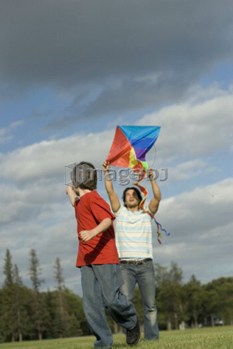 Six year old boy and father try to fly a kite, Assiniboine Park, Winnipeg, Canada