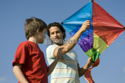 Six year old boy and father try to fly a kite, Assiniboine Park, Winnipeg, Canada