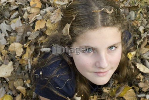 Teen girl lying in leaves, Winnipeg, Canada