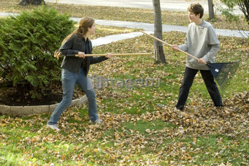 Teen brother and sister fighting with rakes, Winnipeg, Canada