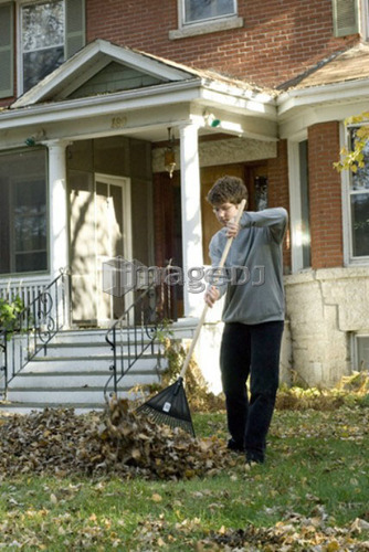 Teen boy listening to music while raking, Winnipeg, Canada