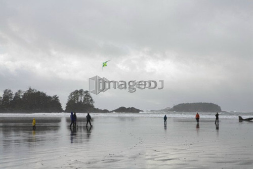 Family on beach flying a kite in winter, Long Beach, Pacific Rim National Park, British Columbia, Canada