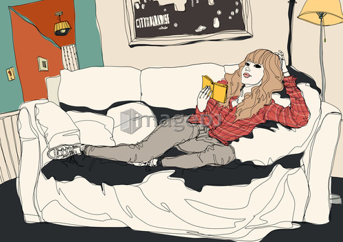 Young woman lying on sofa reading book