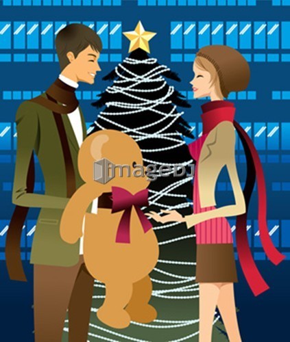 Man giving woman gift, Christmas tree in background