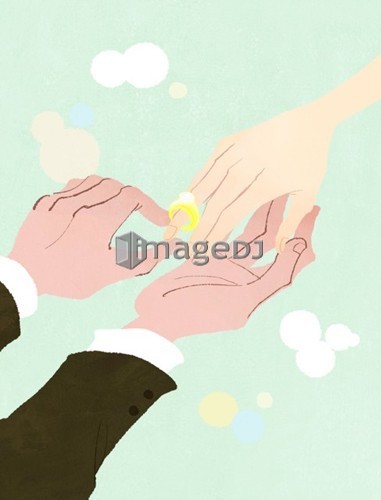 Close-up of man putting wedding ring on woman's finger